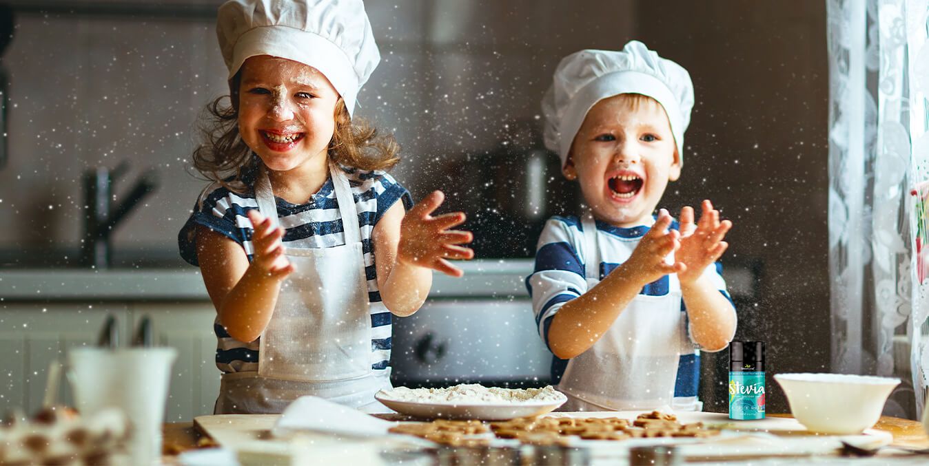 two children playing with flour in a kitchen while baking and wearing chefs hats