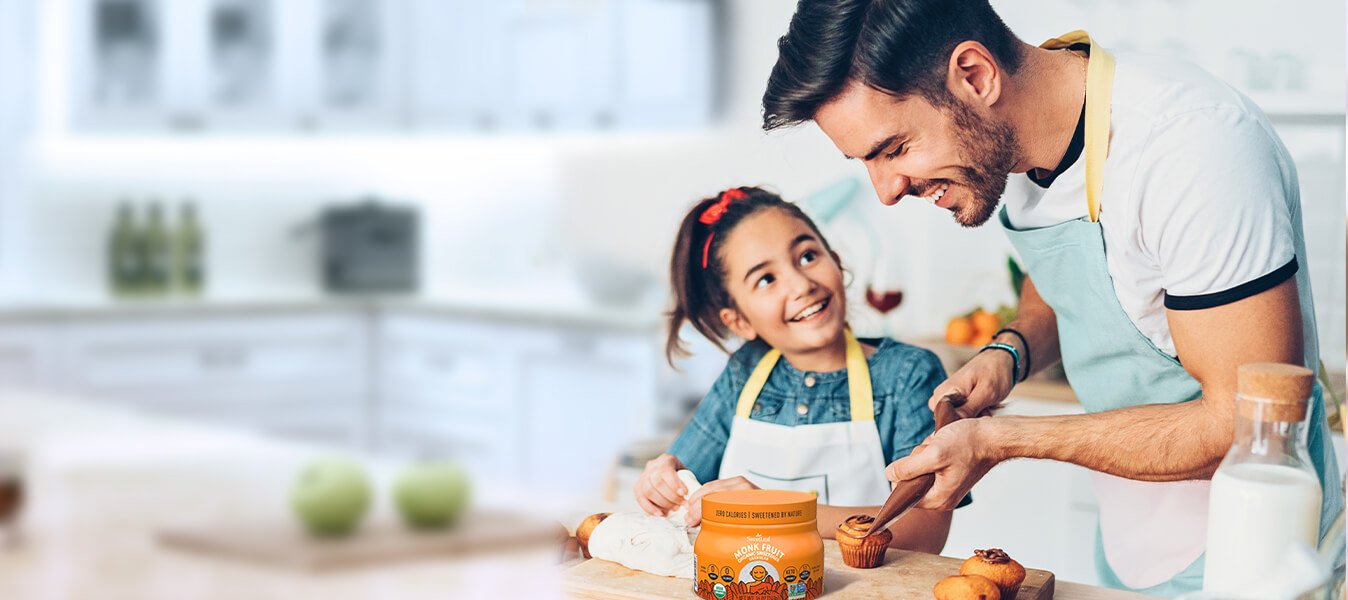 a father and daughter icing cupcakes in a kitchen with sweetleaf stevia on the counter